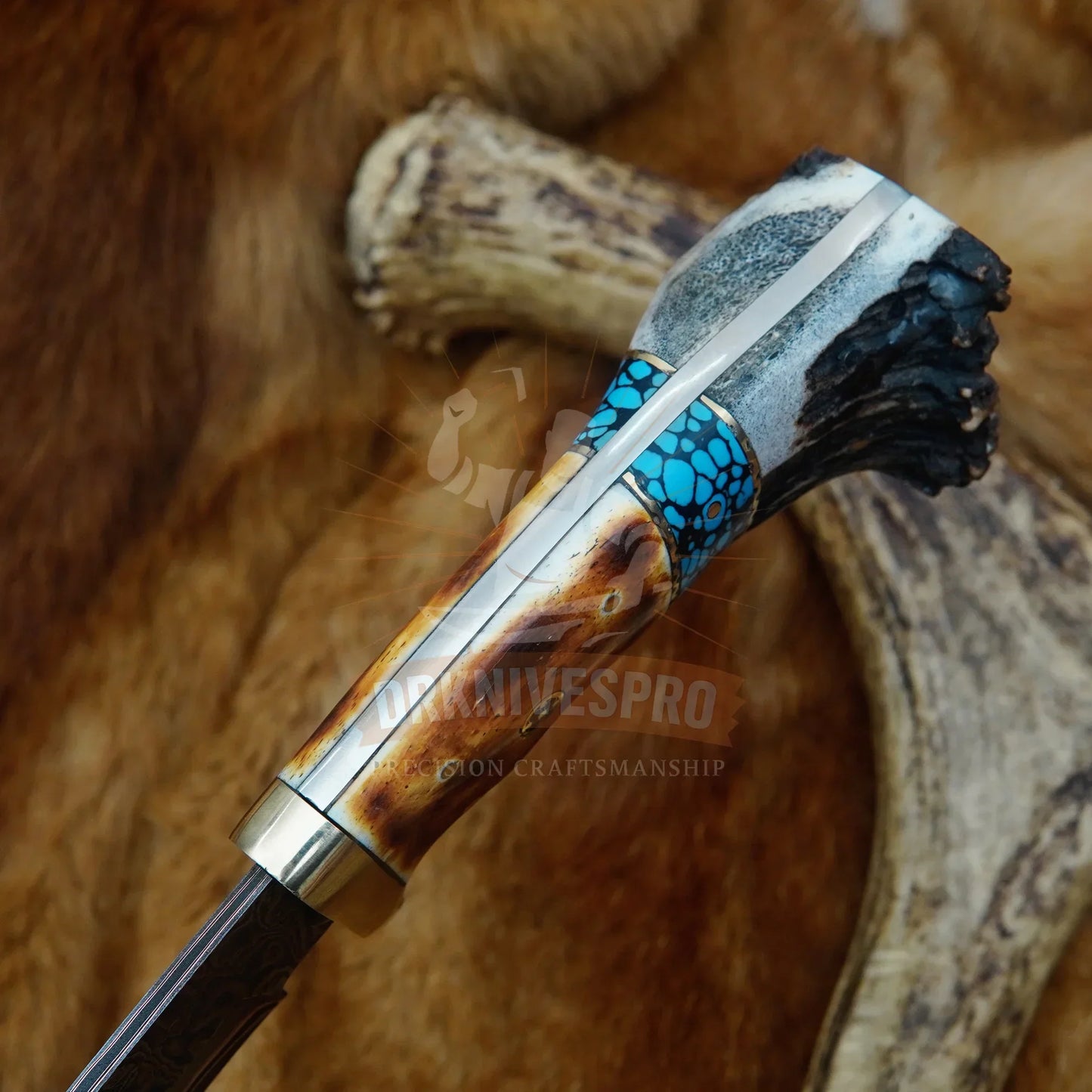 Handmade Damascus knife with exotic antler handle, turquoise inlay, and layered steel blade on fur background