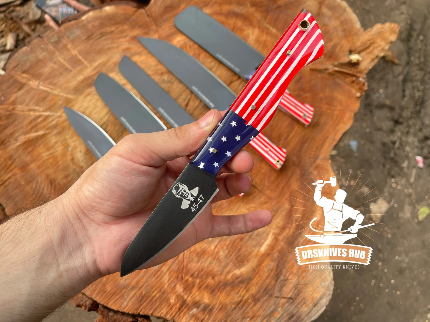 American flag pattern knife with stars and stripes handle, black blade, held over wooden surface