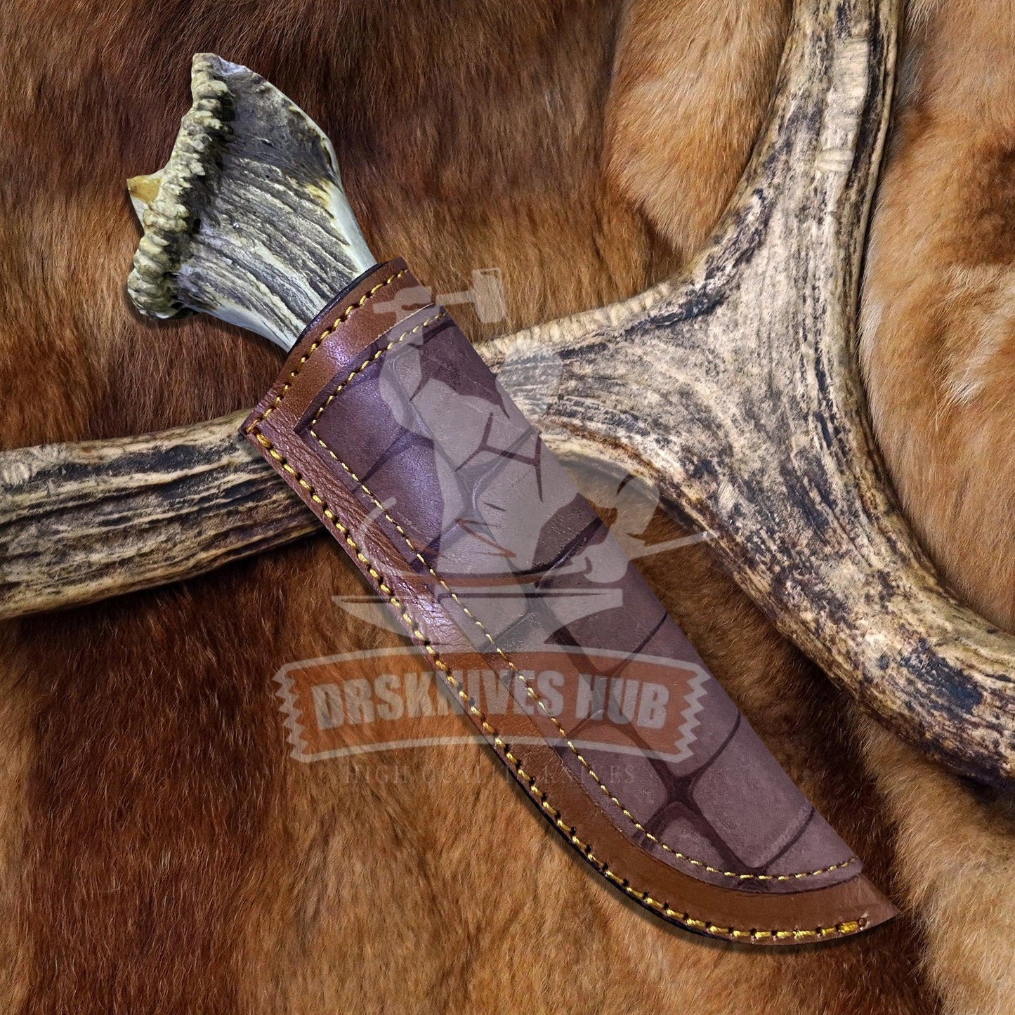 Handmade Damascus knife with antler handle and leather sheath on fur background