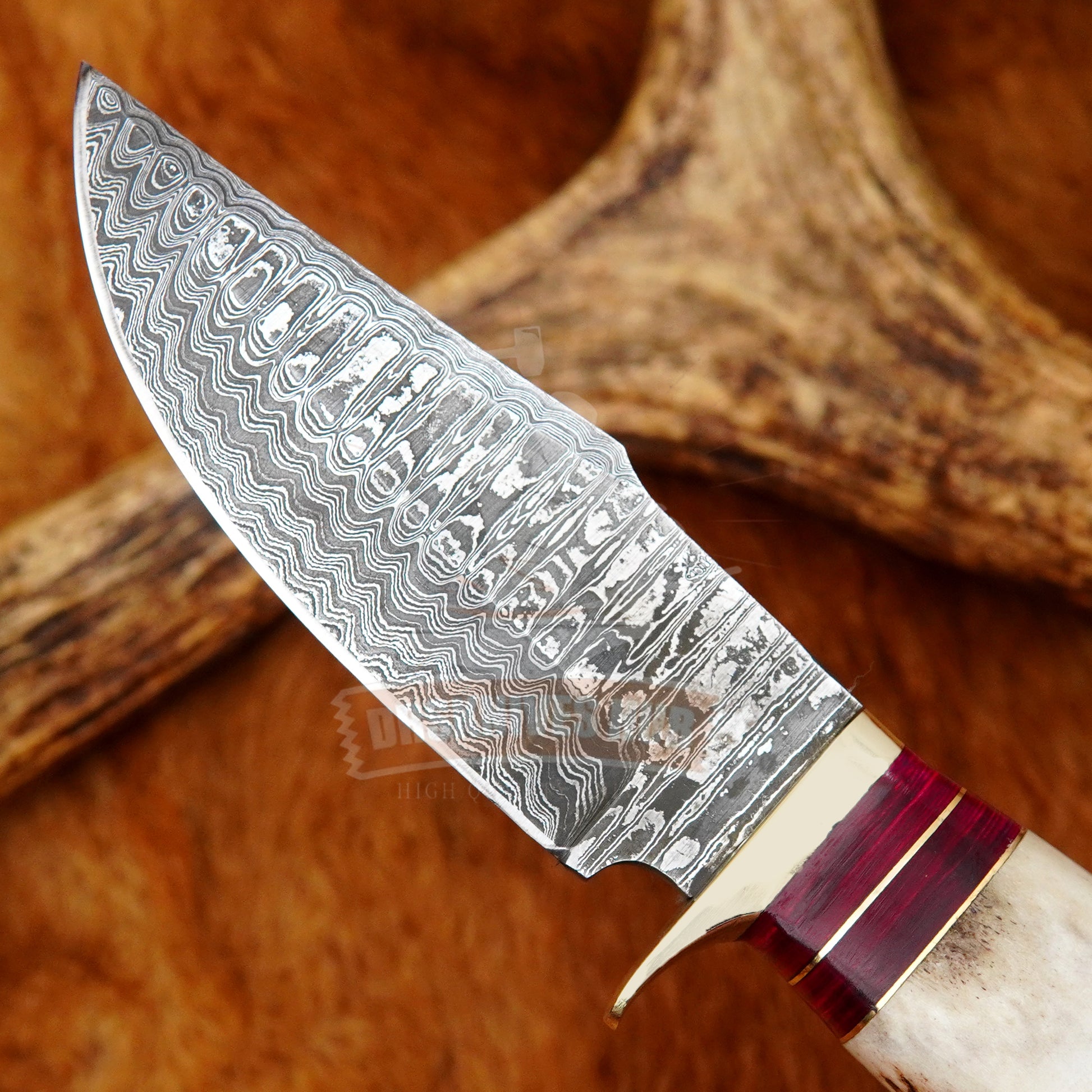 Handmade knife with a patterned blade on a wooden surface