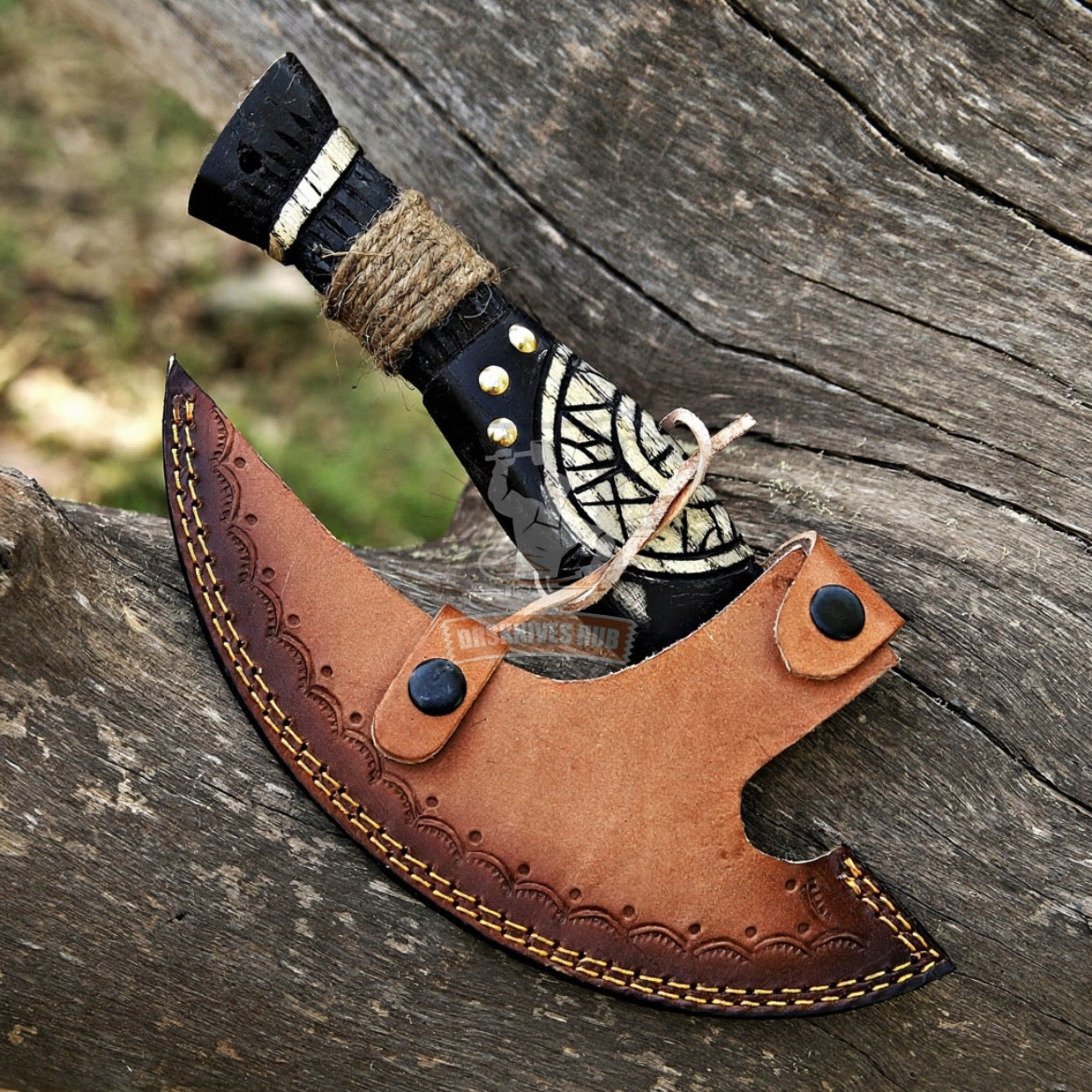 Decorative axe with leather sheath on a wooden surface