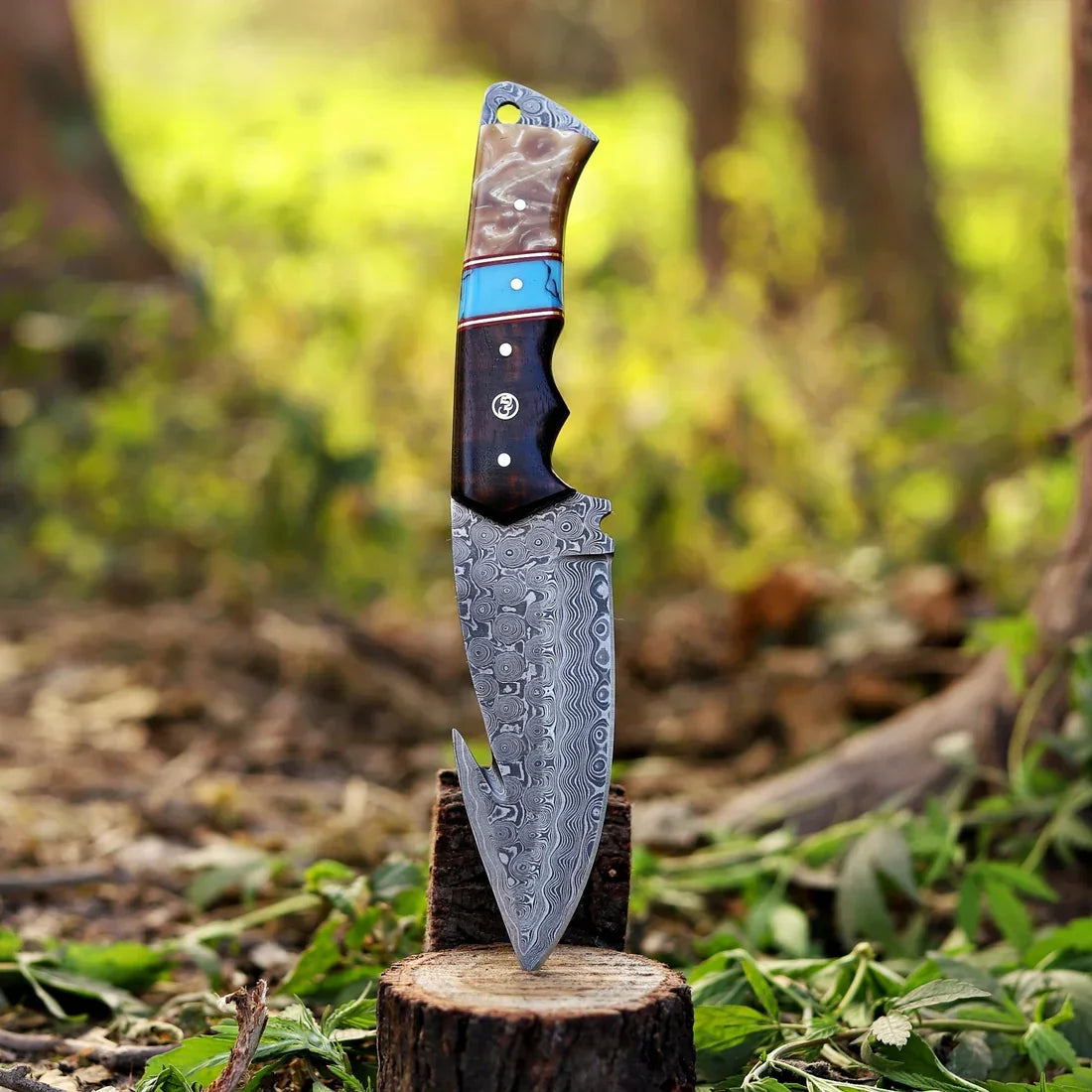 DRSKNIVES HUB 9-inch hunting knife with raindrop Damascus steel blade and rosewood, resin, and brass handle in forest