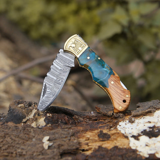 A folding knife featuring a Damascus steel blade and Resin handle, accompanied by a leather sheath cover.