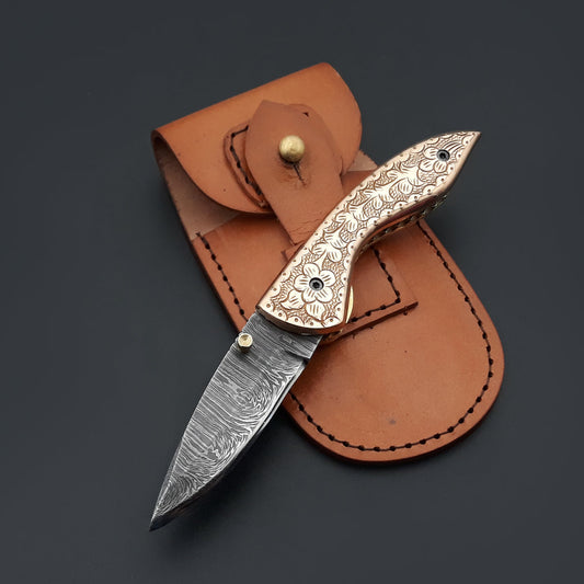 A pocket knife featuring a Damascus steel blade and a copper handle