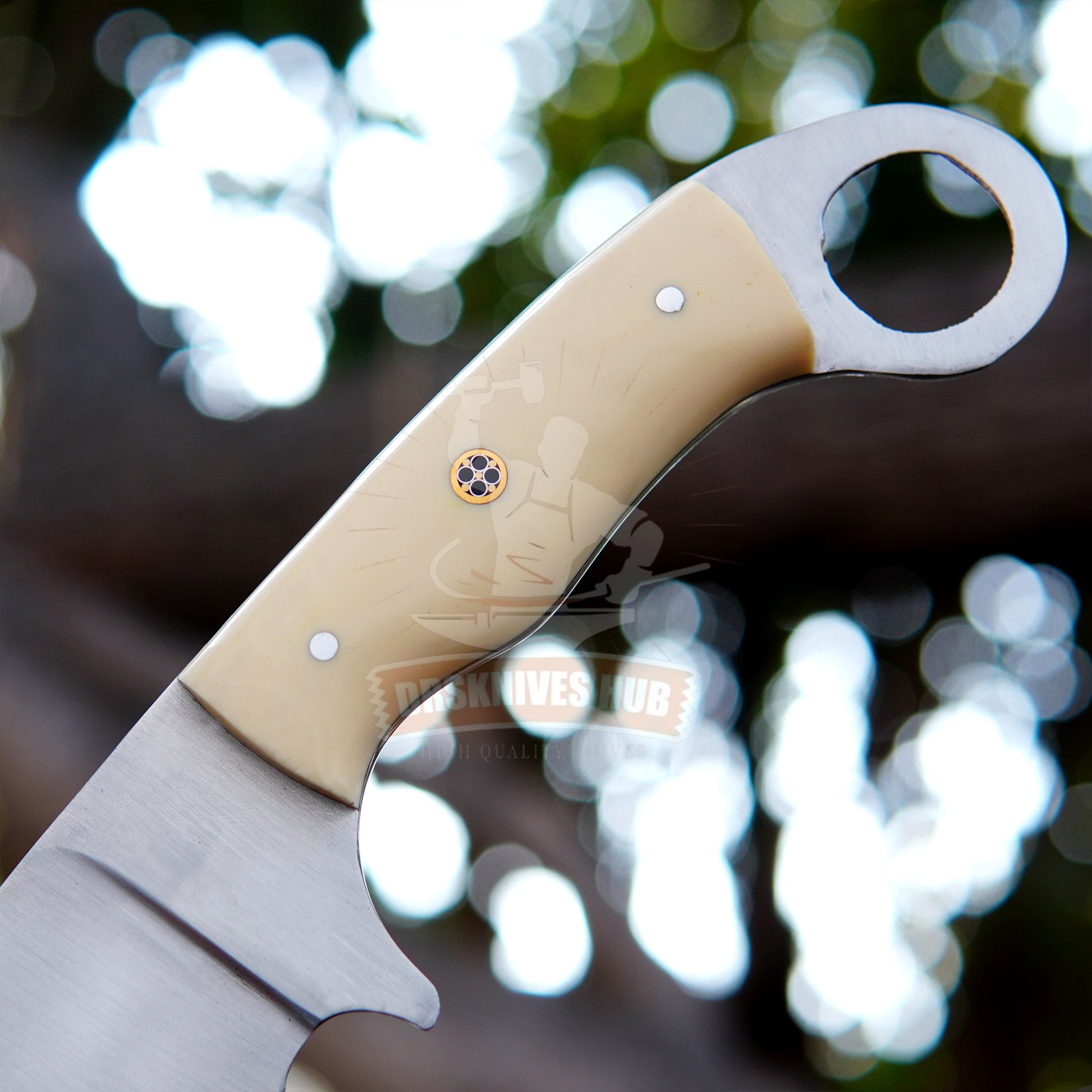 Close-up of a knife with a beige handle and blurred natural background