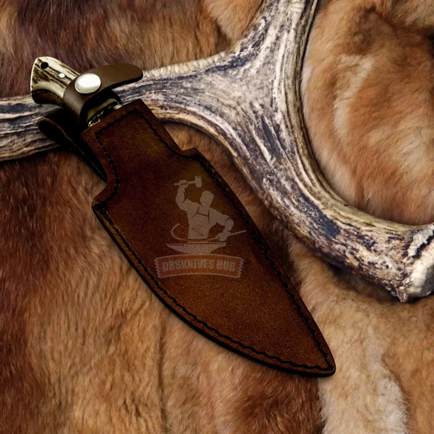 Handmade Damascus knife with bone handle in leather sheath, resting on fur and antler