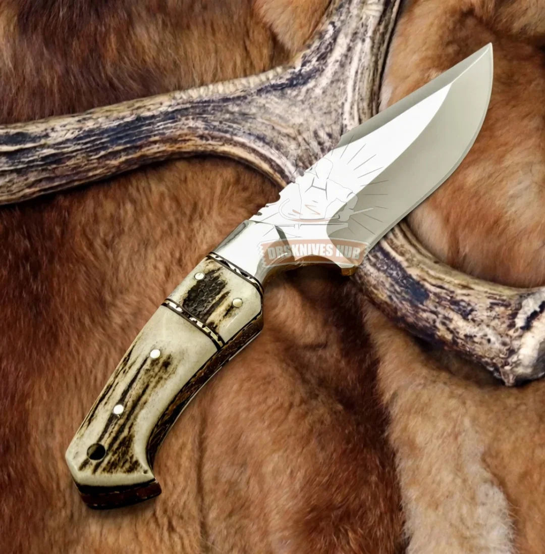 Handmade Damascus hunting knife with stag antler handle, displayed on fur and antler backdrop